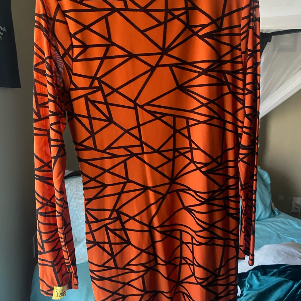 Long sleeve short burnt orange dress with black lines.
